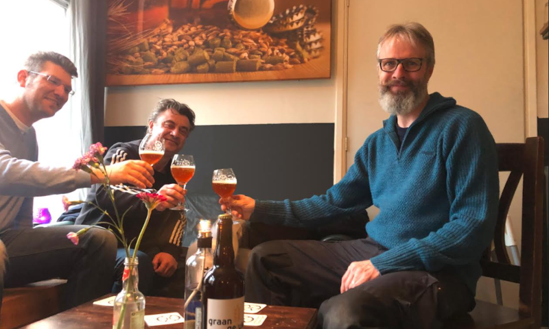 Drie mannen proosten met GraanGeluk bier